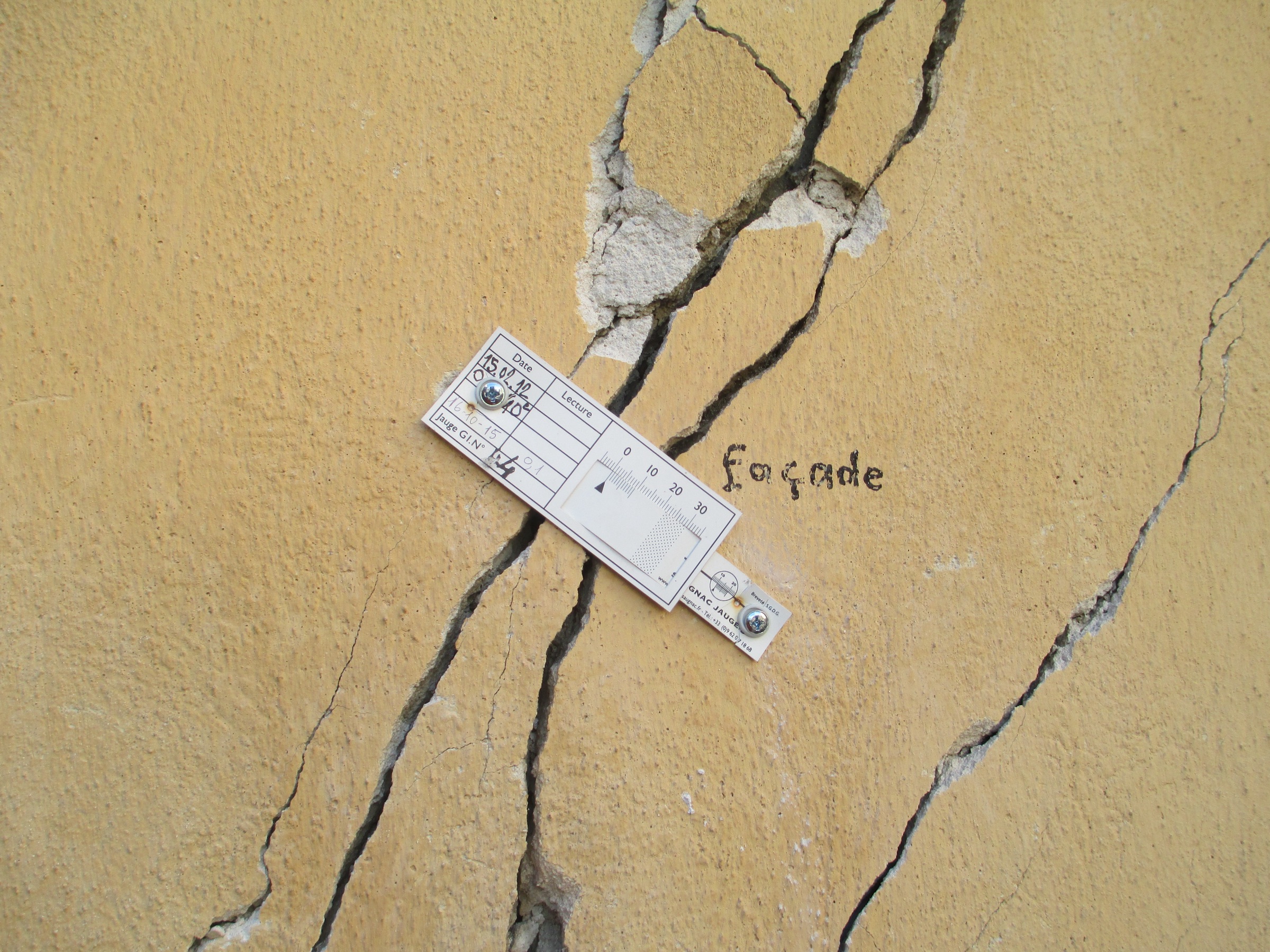 Fissures traversantes en façade d'un bâtiment à Breil
